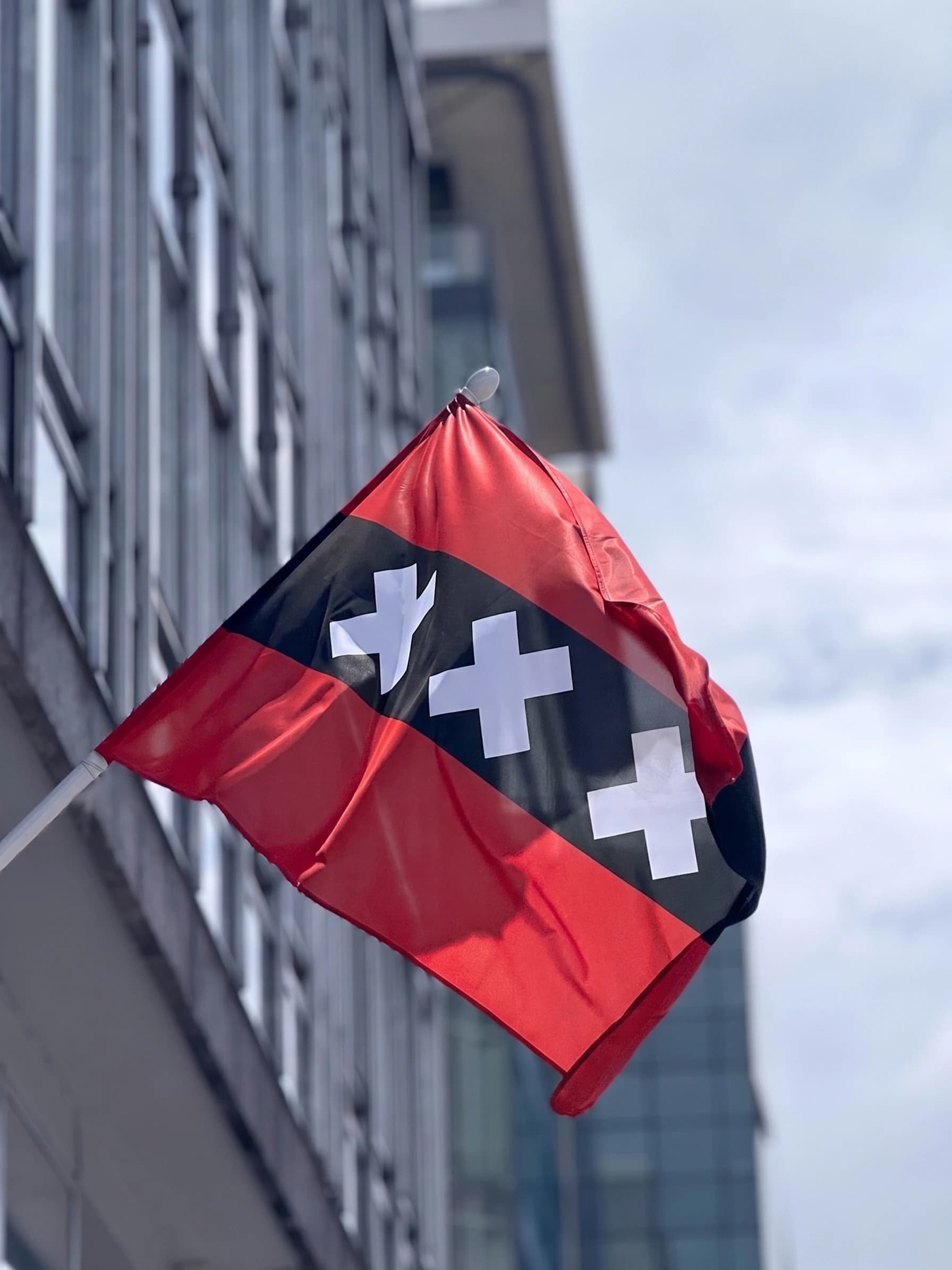 Amsterdamse vlag, rood en zwart met drie witte kruisen, van Hemptex® hennepdoek aan een gevelstok