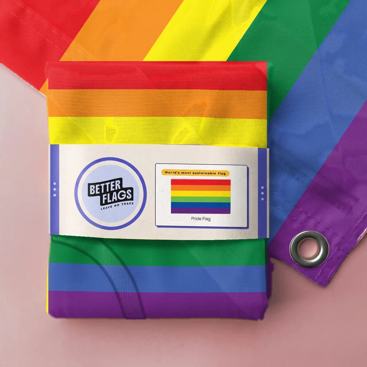 Opgevouwen regenboogvlag in een papieren wikkel van Better Flags (mock-up van de verpakking)